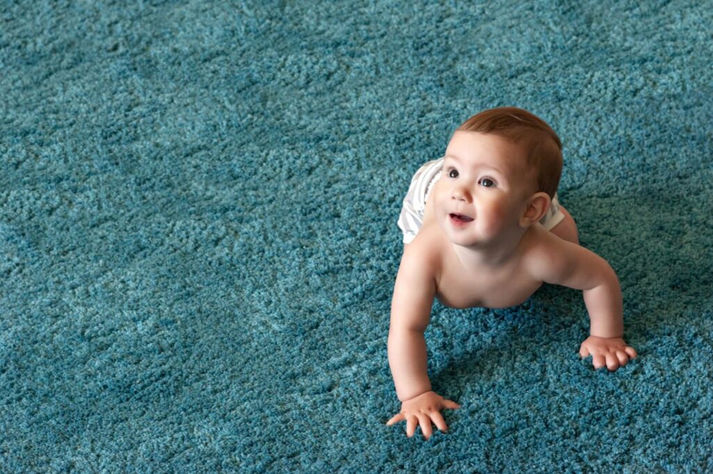 childhood-babyhood-and-people-concept-hands-of-baby-crawling-on-floor-or-carpet