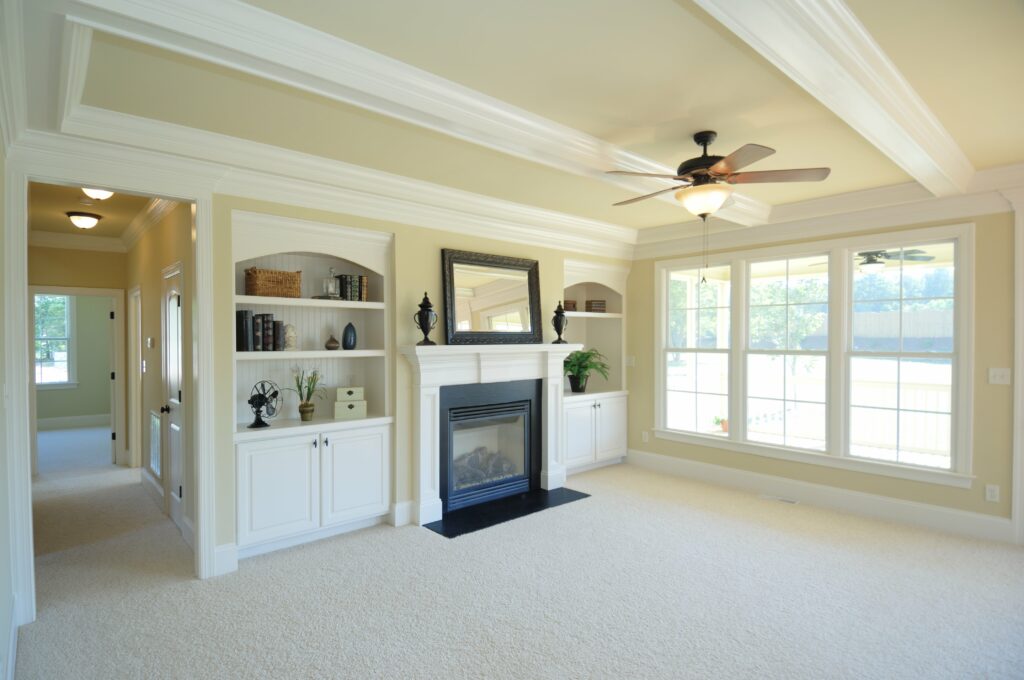 Living room with white carpet and white mantle and built-in shelves