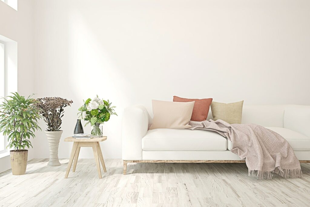 wood flooring in room with white couch and plants