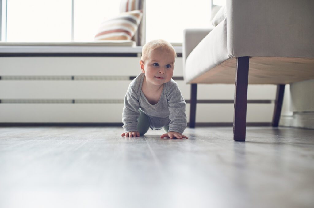 little baby boy crawling on floor at home.