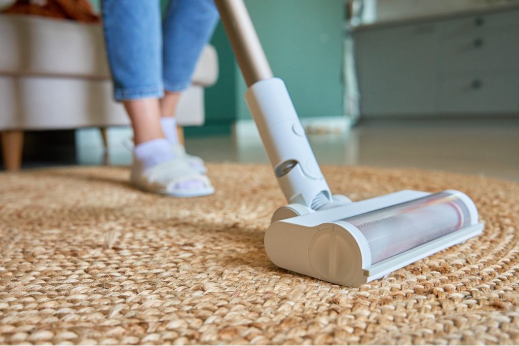 close up using vacuum to clean carpet