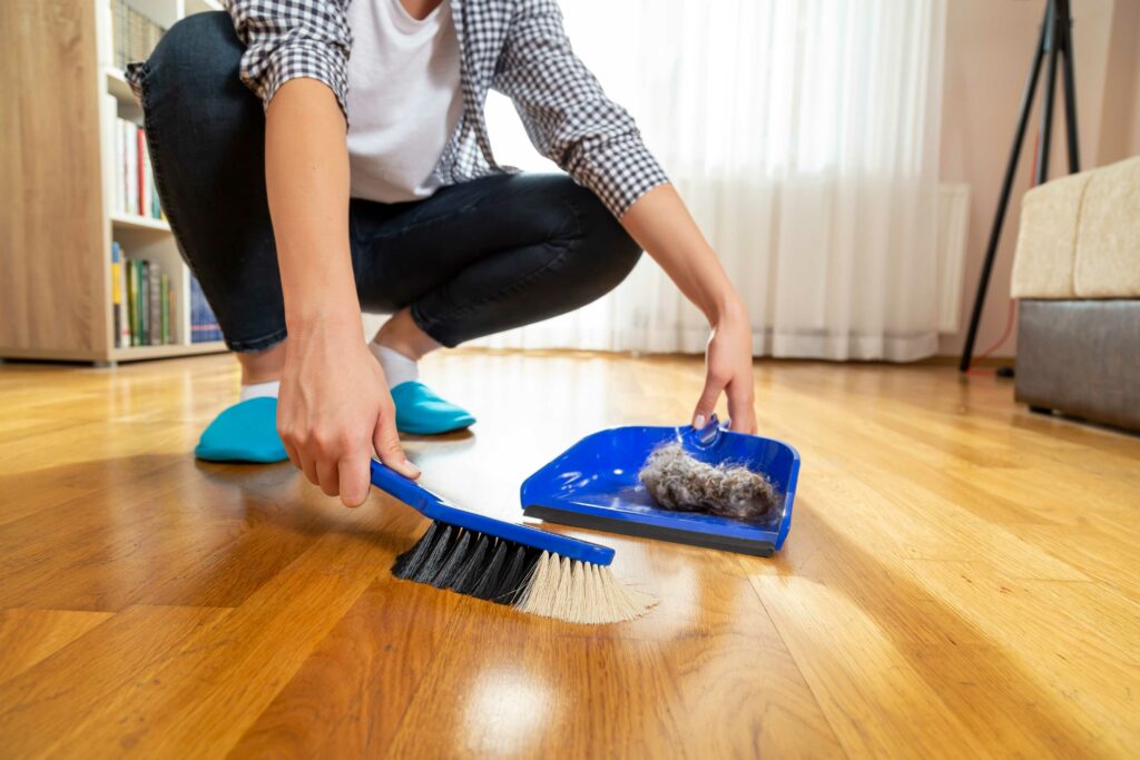 woman sweeping fur hair on the floor