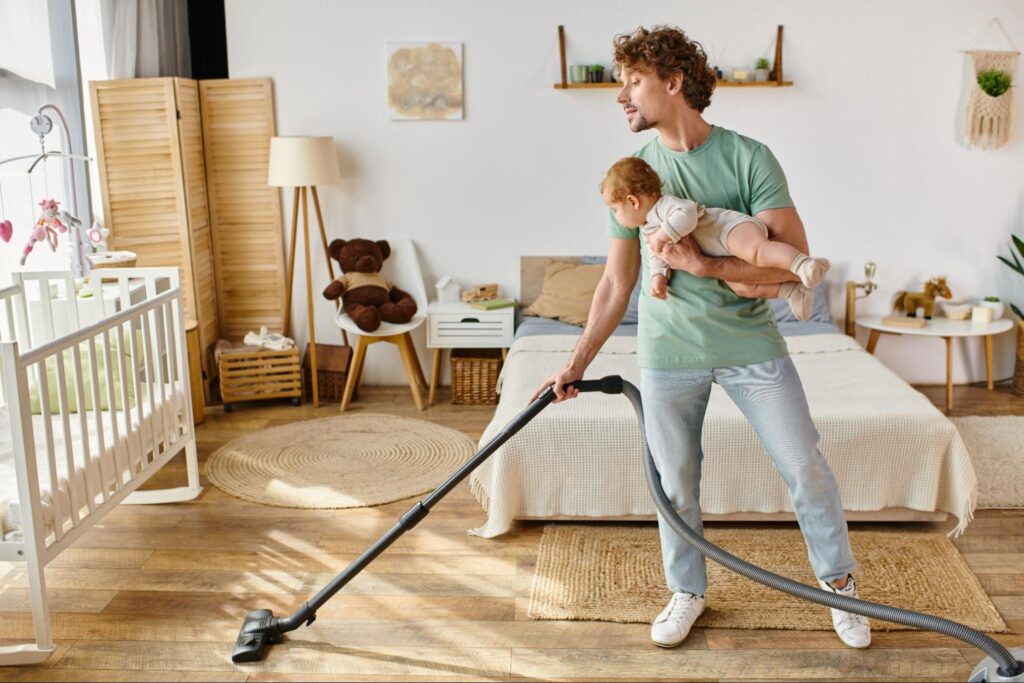 happy-toddler-helping-mother-vacuum-hardwood-floor-in-living-room