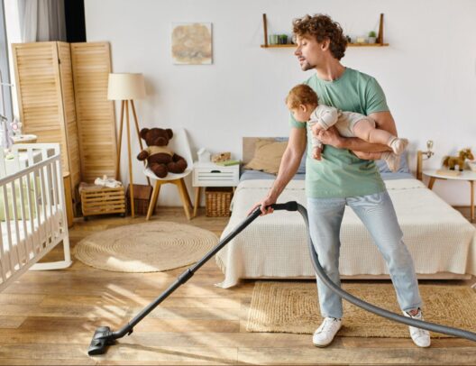 happy-toddler-helping-mother-vacuum-hardwood-floor-in-living-room