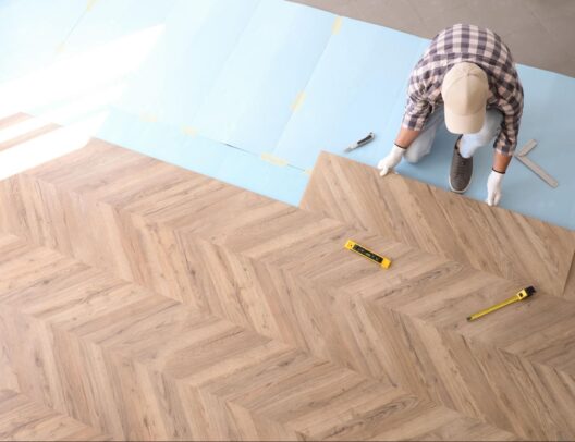 worker-installing-laminated-wooden-floor-indoors-above-view